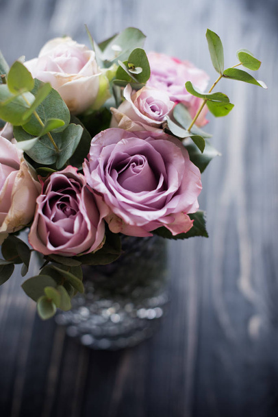μοβ, μοβ χρώμα φρέσκο θερινά τριαντάφυλλα σε βάζο με μαύρο tablet - Φωτογραφία, εικόνα