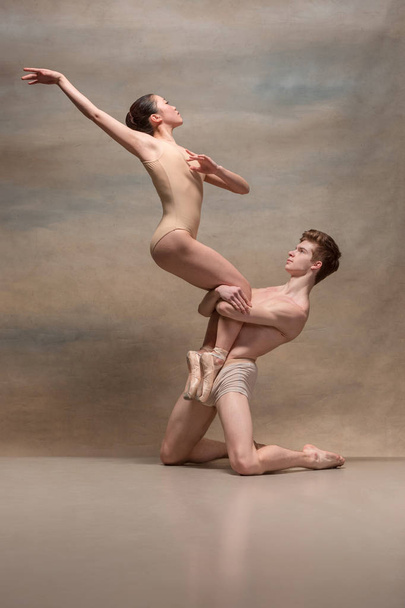 Couple of ballet dancers posing over gray background - Zdjęcie, obraz