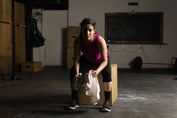 Γυναίκα που αναπαύεται μετά που εργάζονται σε ένα γυμναστήριο - Φωτογραφία, εικόνα