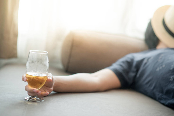 Betrunkener schläft, während er ein Glas Bier hält - Foto, Bild