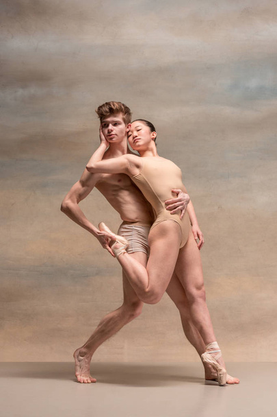 Couple of ballet dancers posing over gray background - Valokuva, kuva