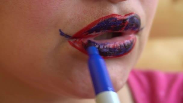 Mädchen bemalt rote Lippen mit blauem Filzstift - Filmmaterial, Video