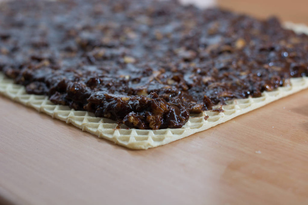Coating chocolate topping with walnuts on cake crust  - Foto, Imagem