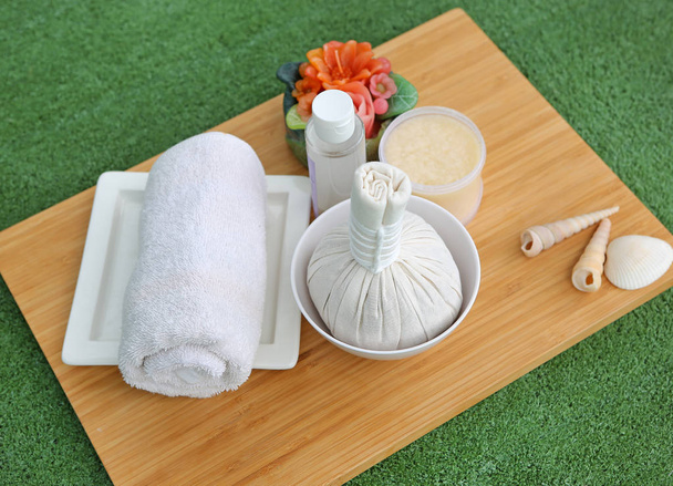 Spa herbal compressing ball with towels and Salt Scrub, Spa concept on bamboo board against white background - 写真・画像