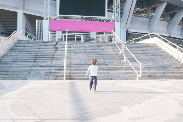 Kind nähert sich Treppe eines großen Stadions - Foto, Bild