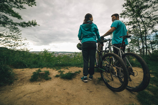 Paar mit Fahrrädern steht auf Klippe - Foto, Bild