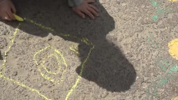 dibujo de la mano del bebé con tiza de colores en el pavimento
 - Imágenes, Vídeo