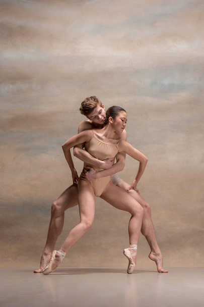 Couple of ballet dancers posing over gray background - Photo, Image