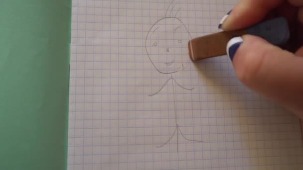 Zenske ruky vymažou mužík v guma poznámkového bloku - Záběry, video