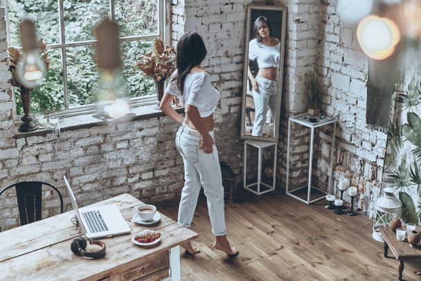 brunette woman looking in mirror - Фото, изображение
