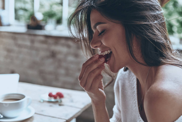 brunette woman eating tasty croissant  - Photo, Image