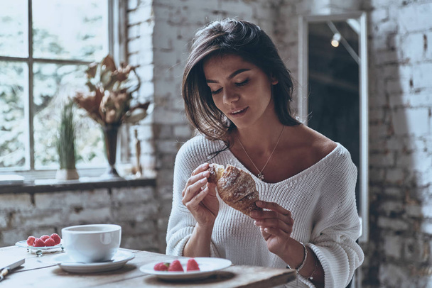 woman enjoying fresh croissant - Photo, Image