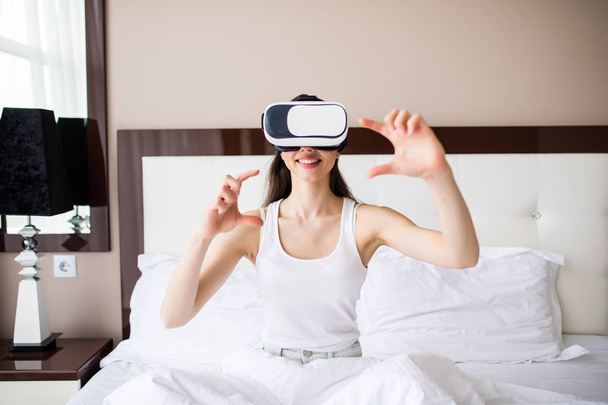 Mujer jugando VR en casa en su cama
 - Foto, imagen