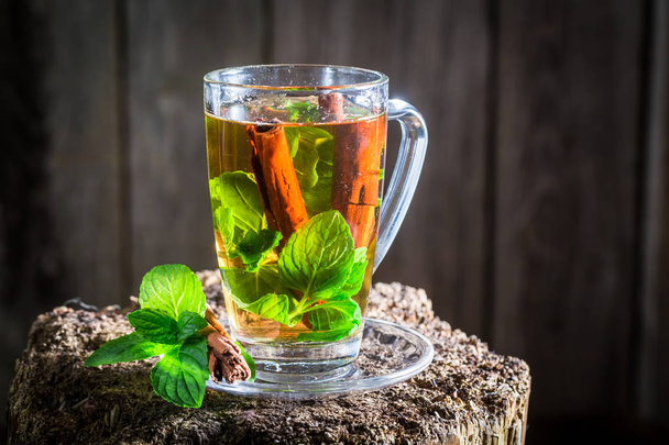 Hot tea with cinnamon bark and green leaves - Zdjęcie, obraz