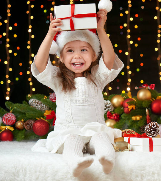 child girl portrait in christmas decoration, happy emotions, winter holiday concept, dark background with illumination and boke lights - Photo, Image