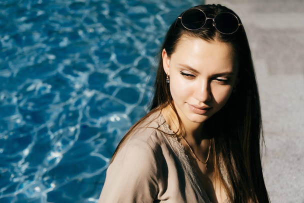 Hot woman relax near swimming pool,toned skin,sunglasses,vacatio - Φωτογραφία, εικόνα