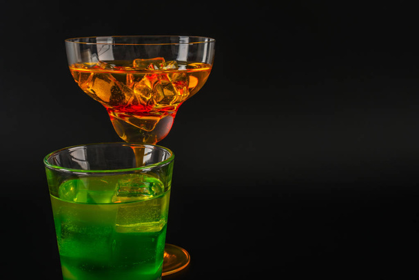 Красочный напиток в коктейльном бокале, с кубиками льда, летний напиток
 - Фото, изображение