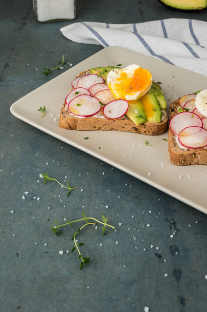 Sandwiches with avocado radish cheese and eggs on a rye bread on - Zdjęcie, obraz