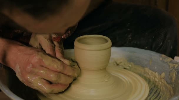 Профессиональный гончар формирования кружку со специальным инструментом в керамической мастерской - Кадры, видео