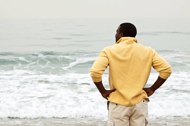 African American man walking on the beach. - Фото, изображение