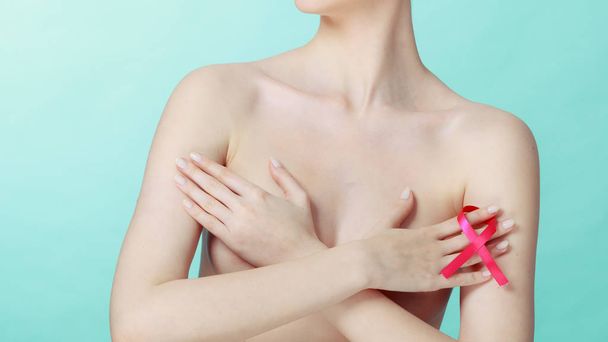 Naked woman with breast cancer awareness ribbon - Foto, afbeelding