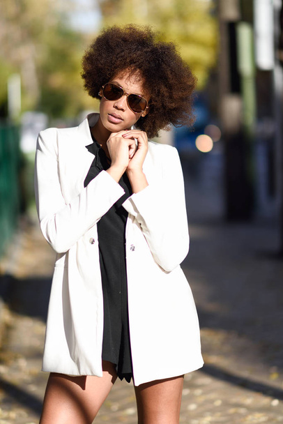 Giovane donna nera con acconciatura afro con occhiali da sole aviatore
 - Foto, immagini