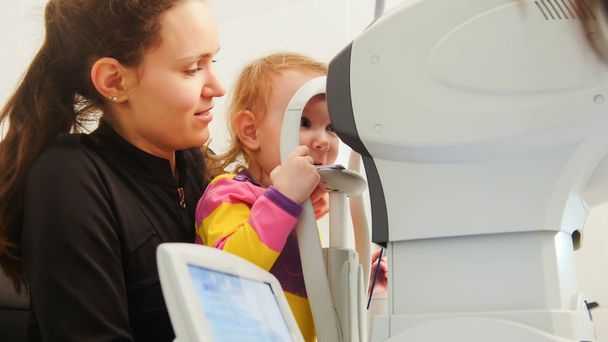 Перевірка зору дитини за допомогою офтальмологічного апарату
 - Фото, зображення