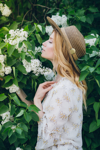 Blond woman with lilac flowers in the spring - 写真・画像
