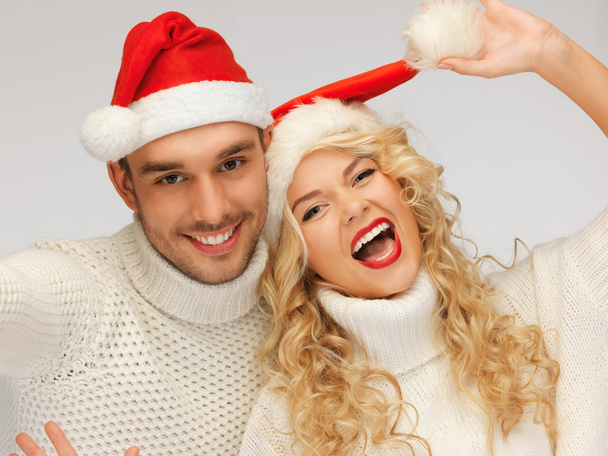 Family couple in sweaters and santa's hats - Valokuva, kuva