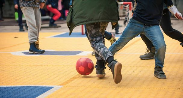 Студентські діти грають у футбол з м'ячем на шкільному подвір'ї
 - Фото, зображення