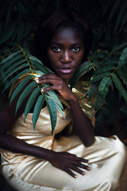 Dark skin model from Nigeria in the golden satin dress. - Foto, imagen