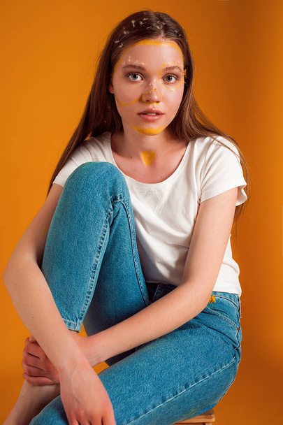Girl with flowers on the yellow background - Valokuva, kuva