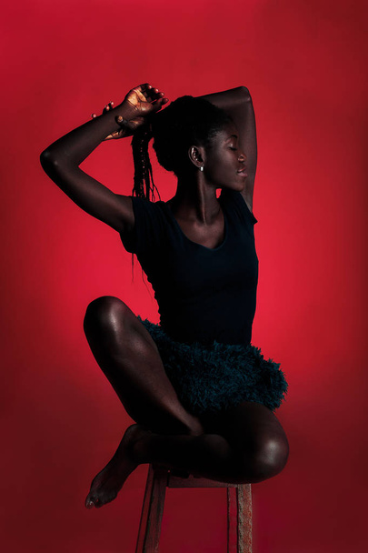 Dark skin model on the red background - Valokuva, kuva