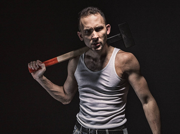 Surprised muscular man with hammer - Photo, Image