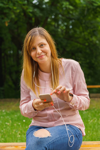 Młoda kobieta SMS-y na inteligentnego telefonu na zewnątrz - Zdjęcie, obraz