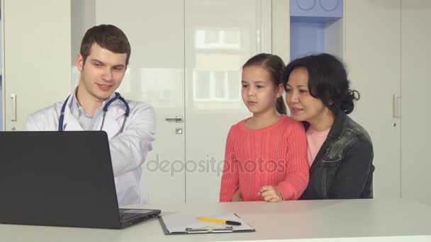Doktorlar gösterir küçük kız ve annesi bir şey üstünde laptop - Video, Çekim