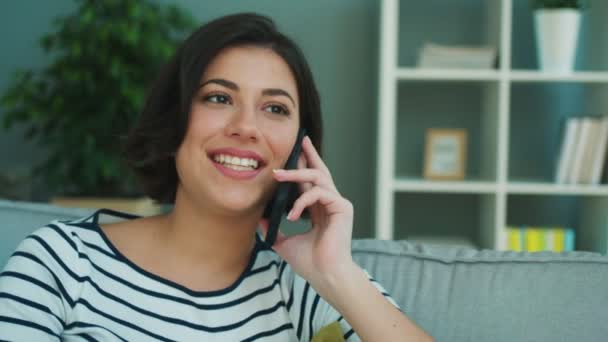 Close up attractive woman talking on the phone on the couch at home. - Video