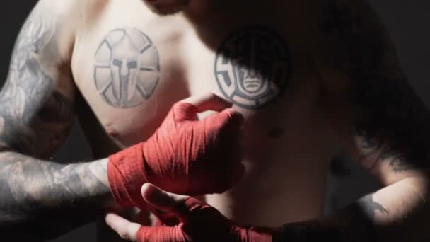 Concentrado Muay Thai boxeador masculino envolviendo vendajes en sus manos, lento-mo
 - Metraje, vídeo