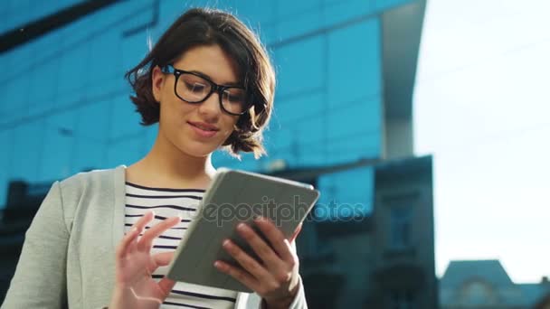 Mladá bruneta podnikatelka pomocí zařízení tablet na městské ulici. Detailní záběr. - Záběry, video