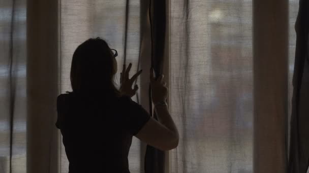 Žena otevírání tmavé záclony nechat teplé letní slunce v jejím útulném domů, slowmotion - Záběry, video