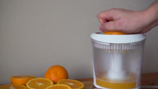 Κάνει φρέσκο χυμό πορτοκάλι με ηλεκτρικό αποχυμωτή - Πλάνα, βίντεο