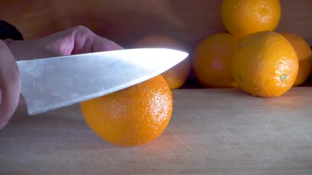 Sliced orange on a wooden board - Filmati, video