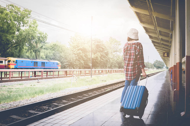 Solo viajero espera maletas esperando su tren en la plataforma
  - Foto, imagen