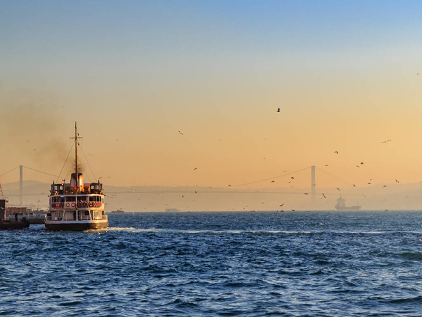 Ferryboat no mar bósforo durante o nascer do sol com ponte bogazici
 - Foto, Imagem