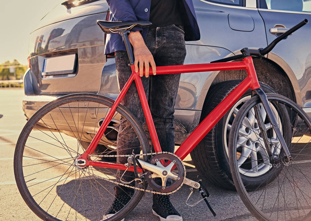 Хипстерский самец держит односкоростной велосипед
 - Фото, изображение
