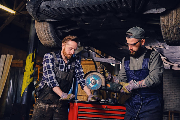 Two mechanics working in a garage - Photo, Image