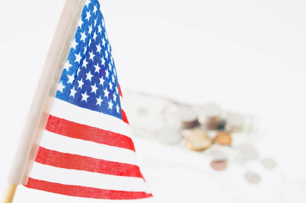Bandiera USA, pila di monete e bambole sullo sfondo, messa a fuoco selettiva. Travel America concetto
 - Foto, immagini