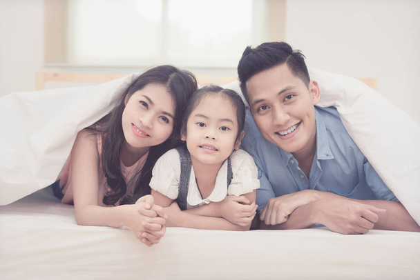 Asian family happy smiling and relax on bed at home. - Foto, Bild
