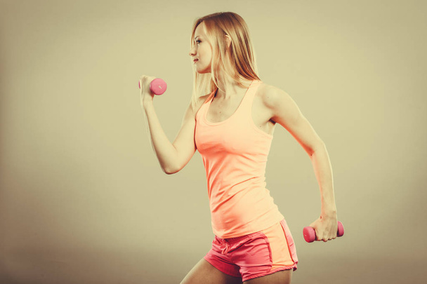 Fitness woman exercising with dumbbells. - 写真・画像