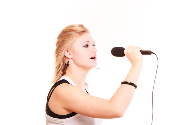 Ξανθιά γυναίκα τραγουδάει στο μικρόφωνο, όψη προφίλ - Φωτογραφία, εικόνα